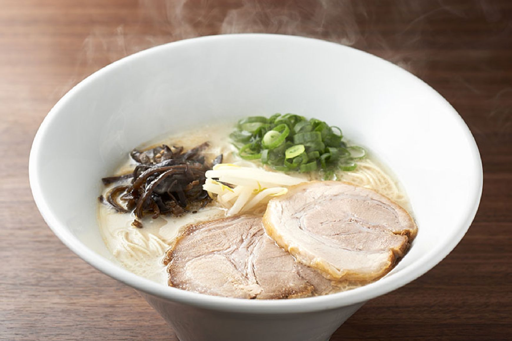 A steaming white bowl of Ippudo Shiromaru — creamy Hakata tonkotsu with thin straight noodles, char siu, spring onion and kikurage