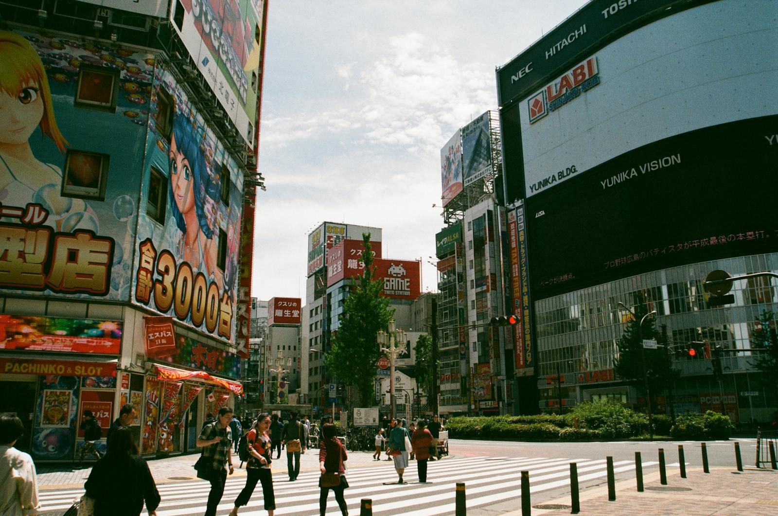 A busy Shinjuku street crammed with crowds, crossings and giant video billboards