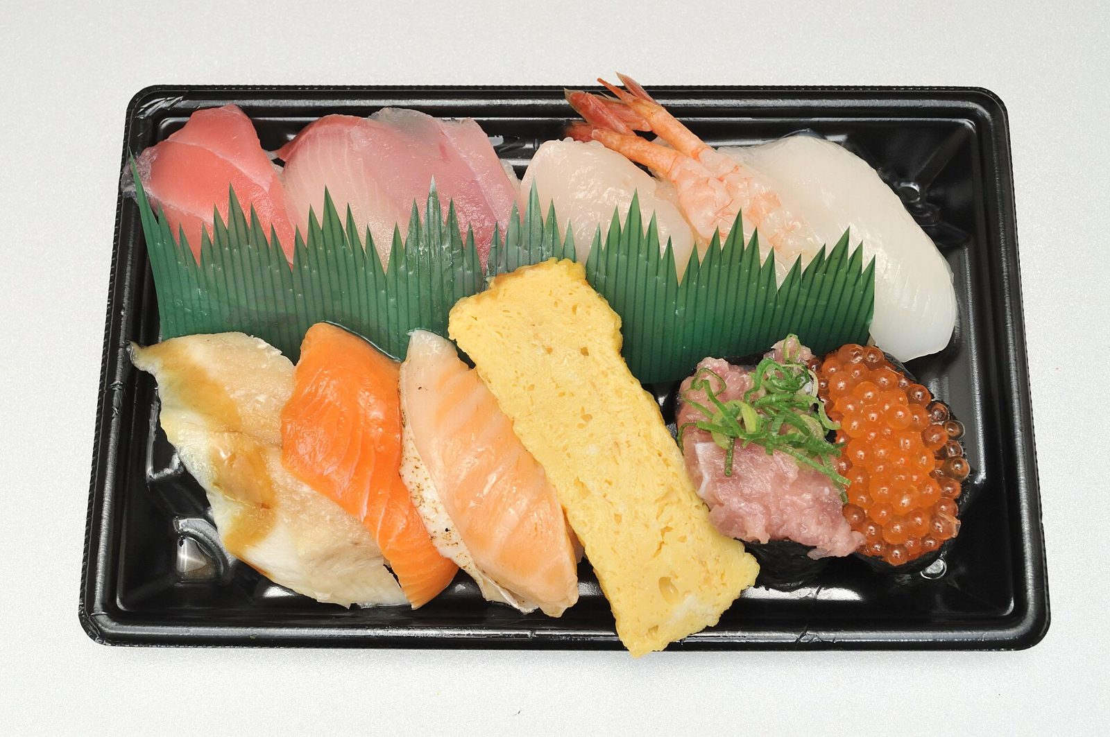 An assortment of Sushiro nigiri sushi in a takeaway tray