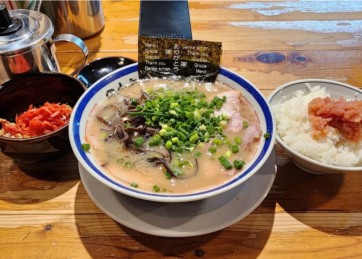 A bowl of Tanaka Shoten Hakata tonkotsu with milky pork-bone broth, kikurage, char siu and the shop's multilingual thank-you nori