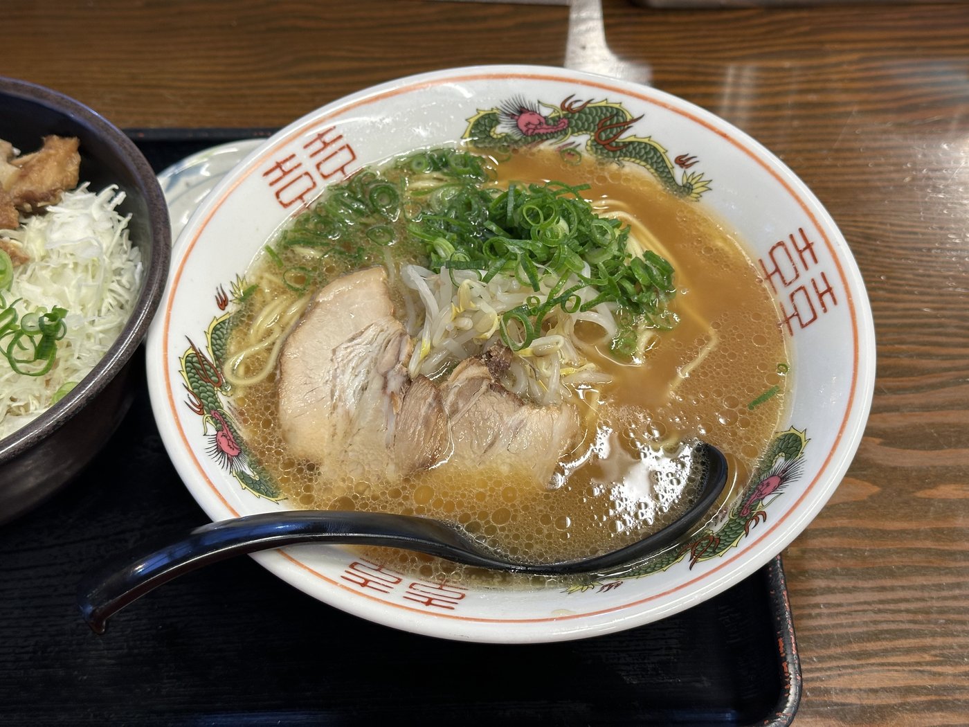 A bowl of Tokyo-style tonkotsu ramen — a browner soy pork-bone broth with char siu, bean sprouts and plenty of spring onion